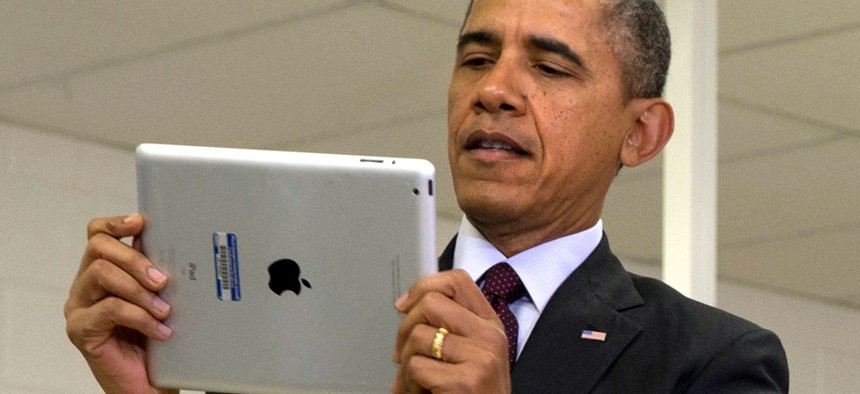Barack Obama holds an iPad at an event at a Maryland school in February.
