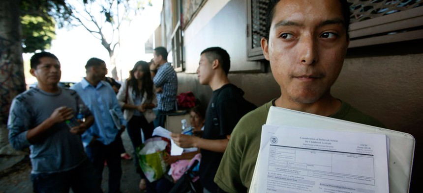 Illegal immigrant Layios Roberto waits outside the offices of Coalition for Humane Immigrant Rights with application papers in Los Angeles.