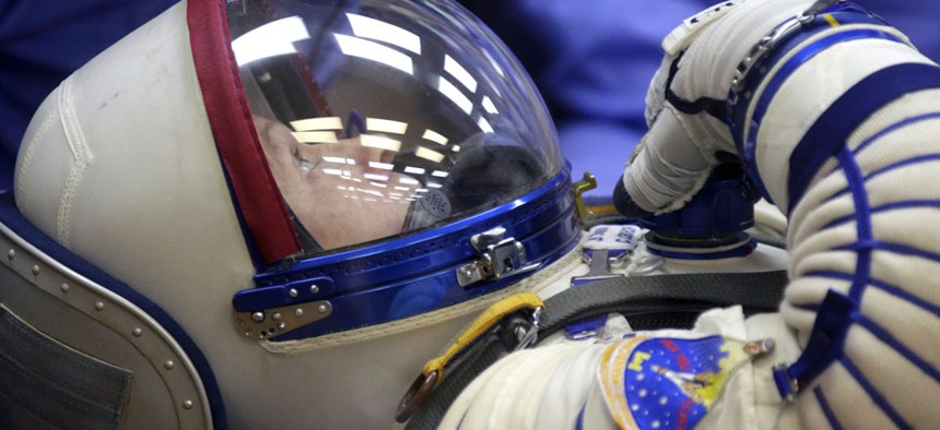 U.S. astronaut Steven Swanson, a crew member of the mission to the International Space Station (ISS) tests a space suit during pre-launch preparations.