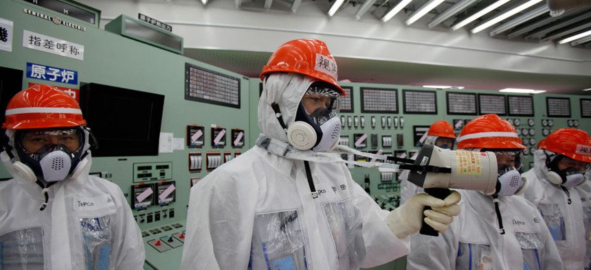 A staff member of the Tokyo Electric Power Co. measures radiation levels inside the central control room of the No. 1 and No. 2 reactors at the Fukushima Dai-ichi nuclear power plant.