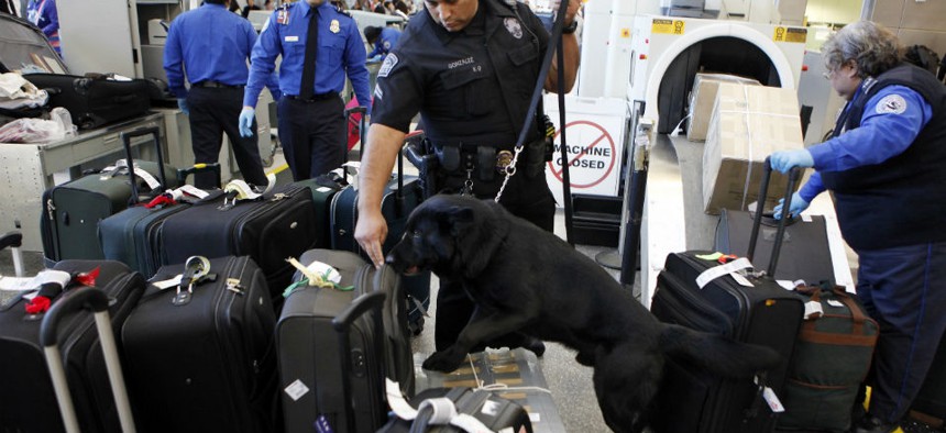 Los Angeles International Airport Enforcement Special Unit police officers use a bomb-sniffing dog to check baggage.