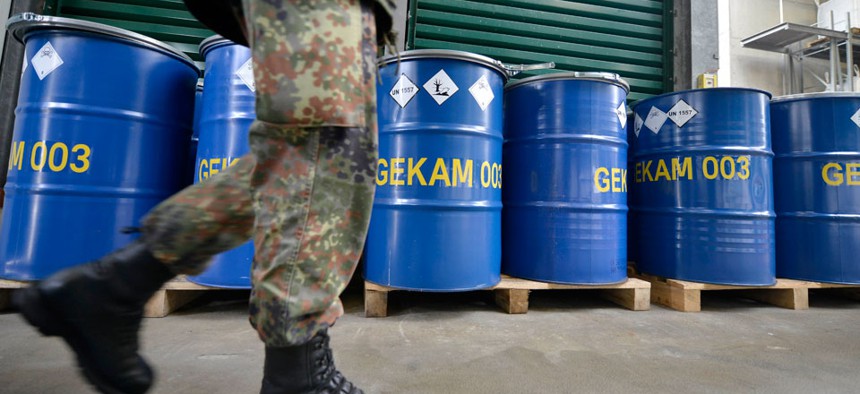 An army officer walks past barrels with chemical waste at the German state-run company GEKA, specialized in the disposal of hazardous materials. The company is tasked to destroy waste material from dismantled Syrian chemical weapons. 