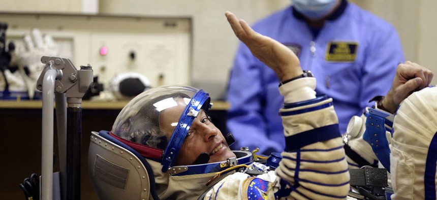 U.S. astronaut Steven Swanson, a crew member of the mission to the ISS, tests a space suit during pre-launch preparations. 