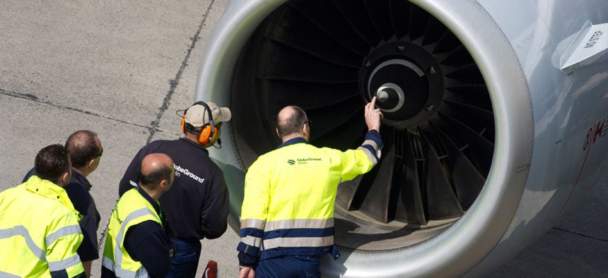 Members of ground staff inspect an engine of a Lufthansa aircraft at Tegel airport in Berlin.