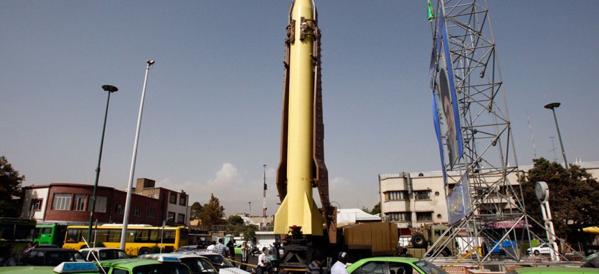 Cars move past a Shahab-3 ballistic missile which is displayed by the Iranian Revolutionary Guard at the Baharestan Square in Tehran.