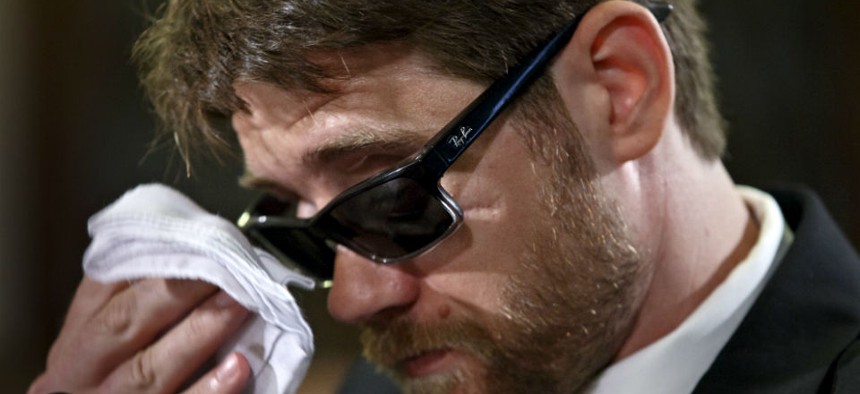 Travis Fugate, a member of the Kentucky National Guard who was blinded by an IED attack in Iraq, wipes his eyes as he testifies on before Congress on May 29, 2014.