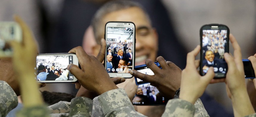 U.S. military soldiers using their smartphones take pictures of President Barack Obama.