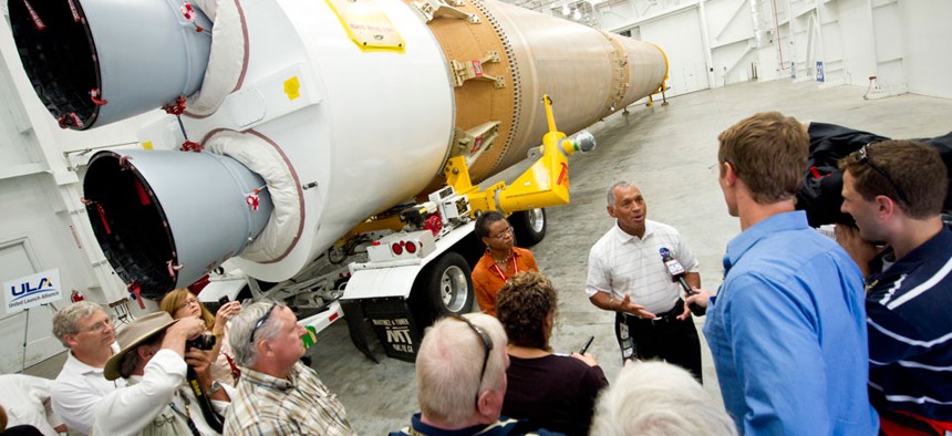 NASA Administrator Charles Bolden, stands in front of the ULA-made Atlas V first stage booster while taking questions from the media