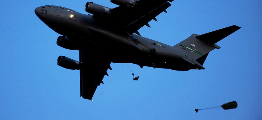 Paratroopers jump from a C-17 in an exercise.