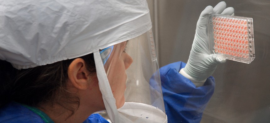 A Centers for Disease Control scientist harvests a bird flu sample in 2013.