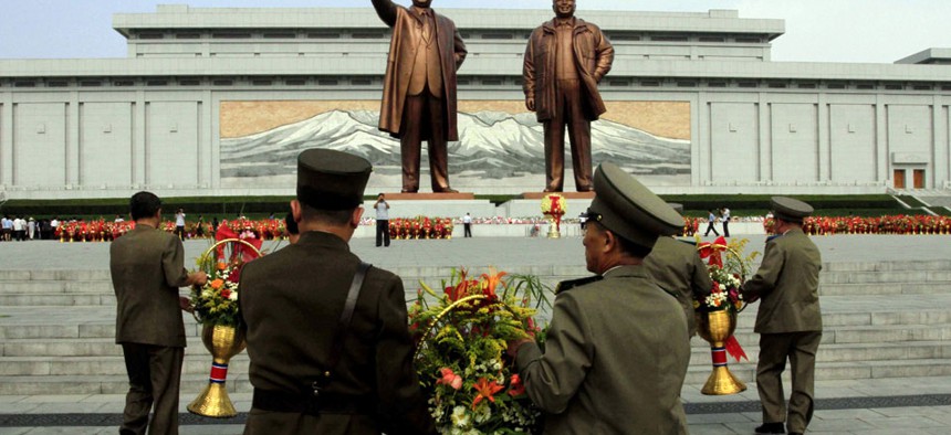 North Korean soldiers bring flowers to the statues of the late leaders Kim Il Sung, left, and Kim Jong Il in Pyongyang, North Korea.