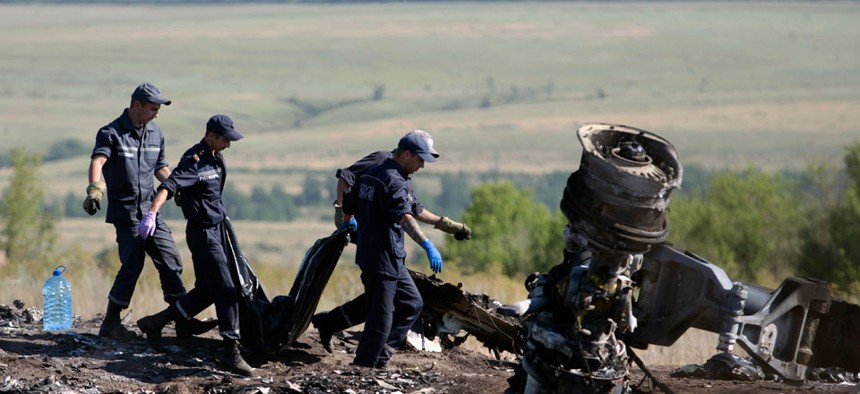 Ukrainian Emergency workers carry a victim's body in a plastic bag at the crash site of Malaysia Airlines Flight 17.