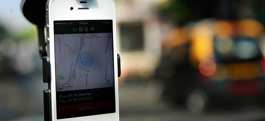 A smartphone is mounted on the glass of an Uber car