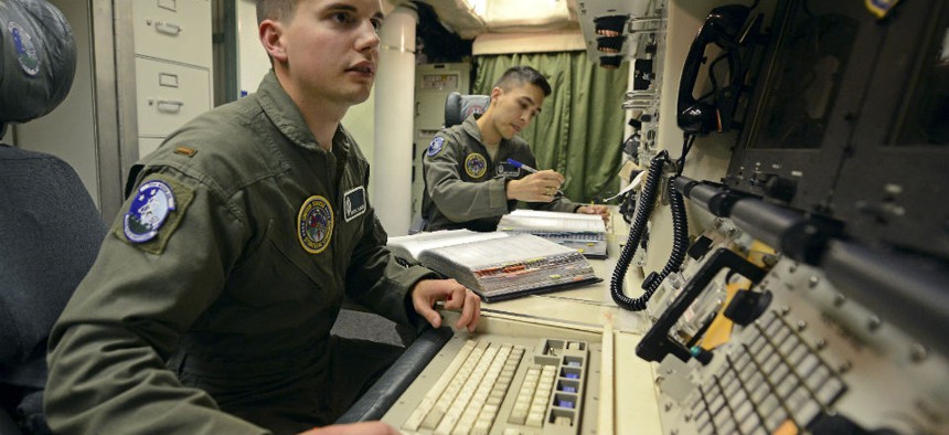 2nd Lt. Oliver Parsons, left, and 1st Lt. Andy Parthum check systems in the underground control room at an ICBM launch control facility near Minot, N.D., in June. 