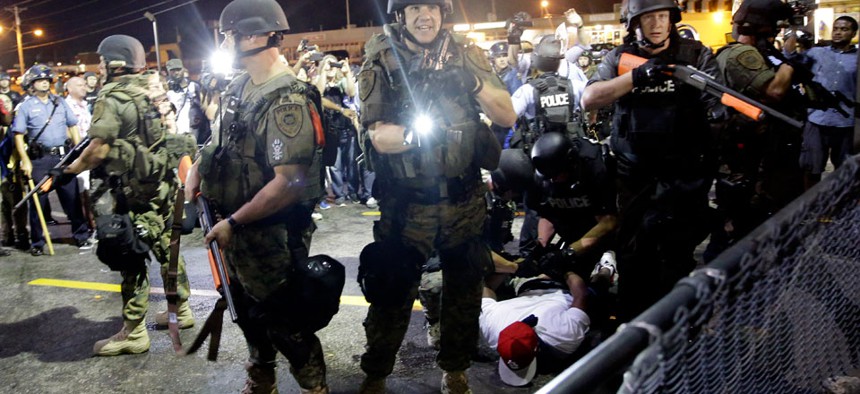 A man is arrested as police try to disperse a crowd during protests in Ferguson, Mo.