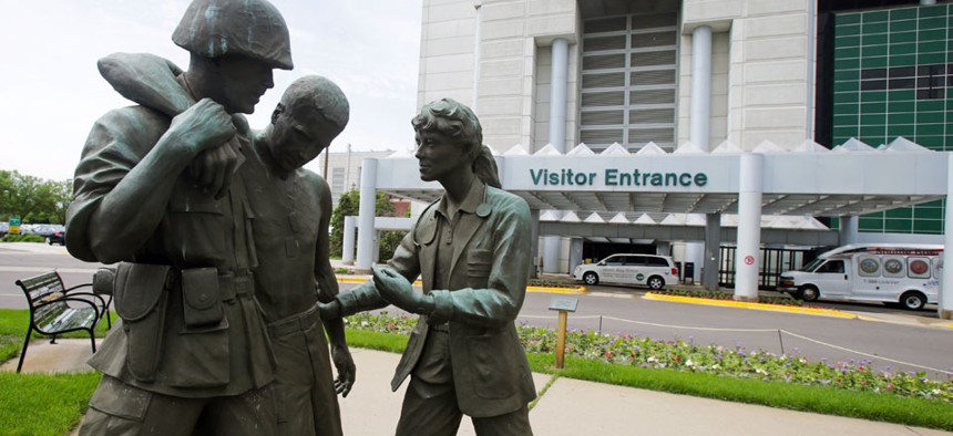 Three statues portraying a wounded soldier being helped, stand on the grounds of the Minneapolis VA Hospital.