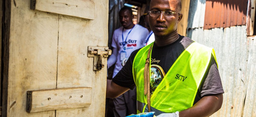 A health worker volunteers distribute bars of soap and information about Ebola in Freetown, Sierra Leone, Saturday, Sept. 20, 2014.