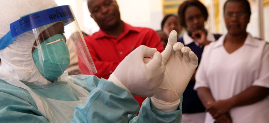 A woman wears protective clothing during a tour of one of the Ebola Centers in Harare, Zimbabwe.