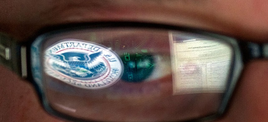 A reflection of the Department of Homeland Security logo in the eyeglasses of a cybersecurity analyst at the watch and warning center of the Department of Homeland Security's secretive cyber defense facility in Idaho Falls, Idaho. 