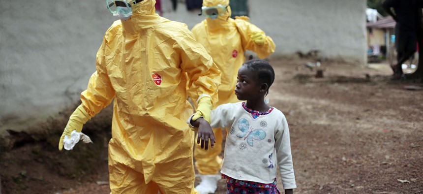 owa Paye, 9, is taken to an ambulance after showing signs of the Ebola infection in the village of Freeman Reserve, about 30 miles north of Monrovia, Liberia.