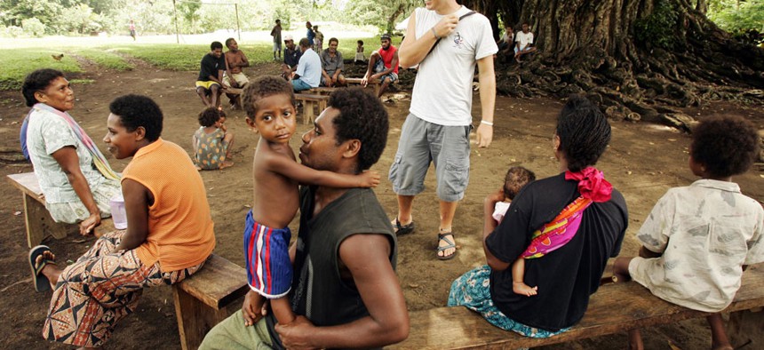 Peace Corps volunteer Joshua Fuder, center, speaks with residents of Lolovoli village on the island of Ambae, part of the Vanuatu islands chain.