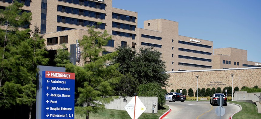 Dallas police vehicles drive toward the emergency room area at Texas Health Presbyterian Hospital Dallas, Thursday, Oct. 16, 2014.