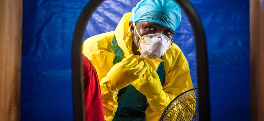 A healthcare worker dons protective gear before entering into an Ebola treatment centre in the west of Freetown, Sierra Leone.