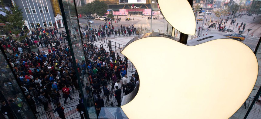 People line up to enter a newly-opened Apple Store in Wangfujing shopping district in Beijing. 