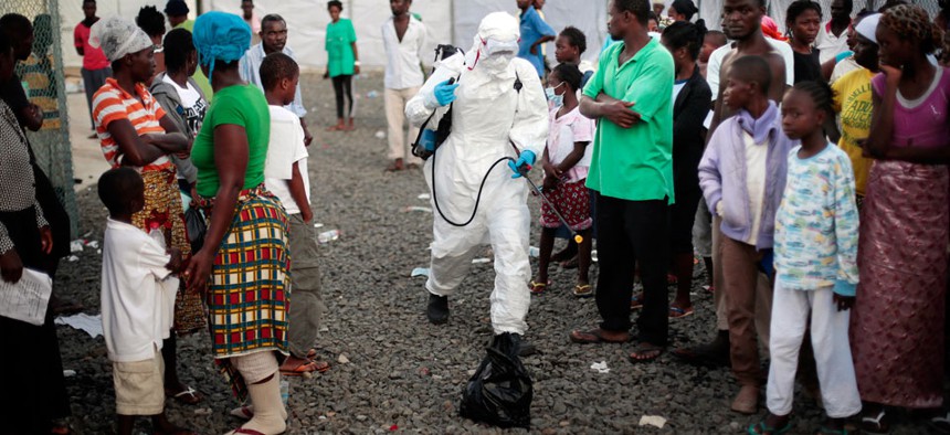 A medical worker sprays people being discharged from the Island Clinic Ebola treatment center in Monrovia, Liberia.