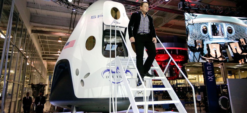 Elon Musk, CEO and CTO of SpaceX, walks down the steps while introducing the SpaceX Dragon V2 spaceship.