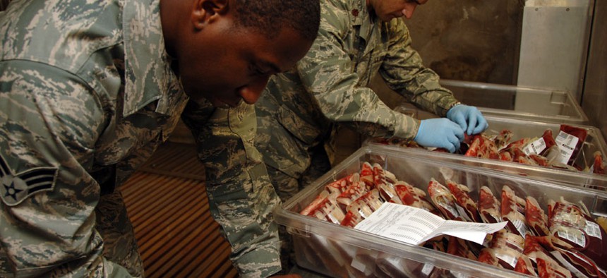 Senior Airman Kendall Thomas, 379th Expeditionary Medical Group Blood Trans-shipment Center laboratory technician, and Maj. Brian Dart, 379th MDG BTC chief, verify blood products before shipment.