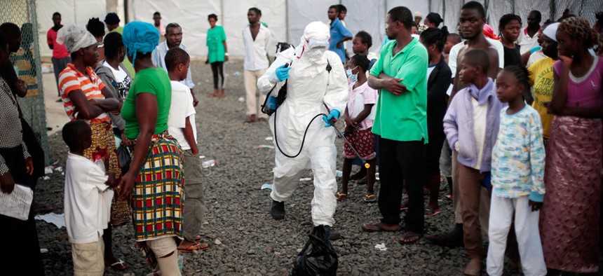  A medical worker sprays people being discharged from the Island Clinic Ebola treatment center in Monrovia, Liberia.