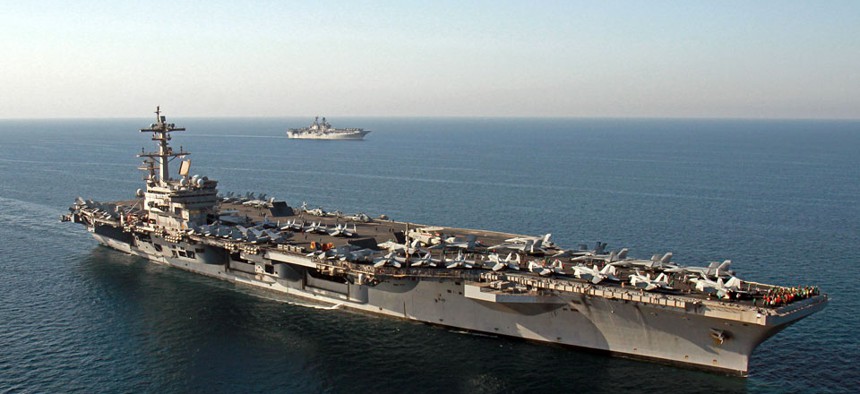 The amphibious assault ship USS Makin Island, background, pulls alongside the aircraft carrier USS George H.W. Bush in the Persian Gulf.