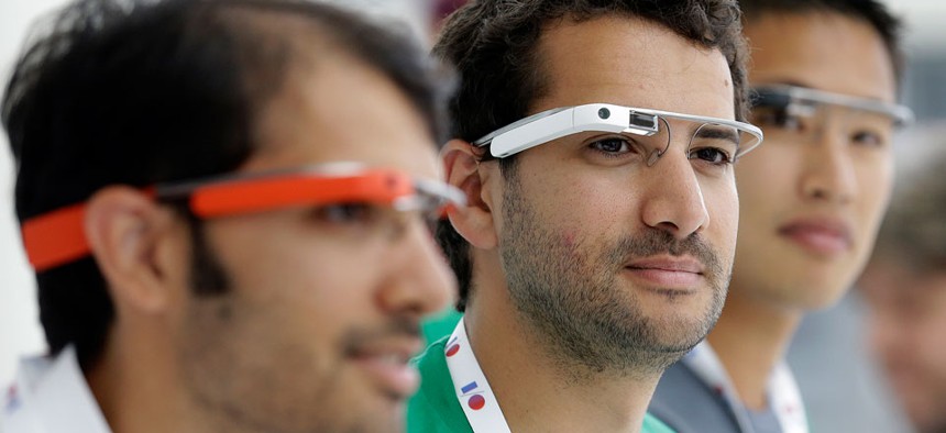 Google Glass team members wear Google Glasses at a booth at Google I/O 2013 in San Francisco.