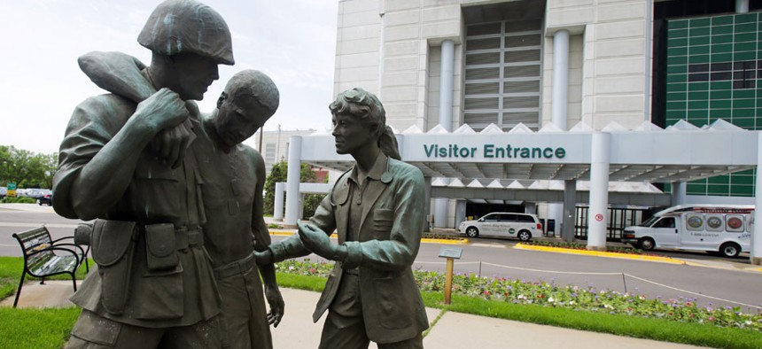 hree statues portraying a wounded soldier being helped, stand on the grounds of the Minneapolis VA Hospital, Monday, June 9, 2014.