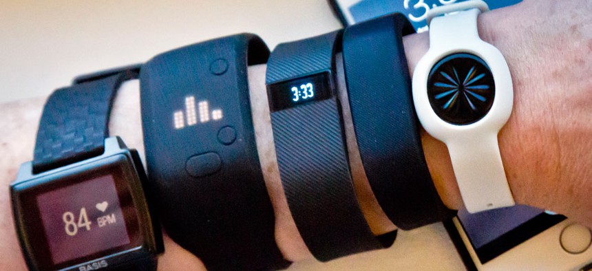 Various fitness trackers are posed for a photo next to an iPhone, Monday, Dec. 15, 2014.