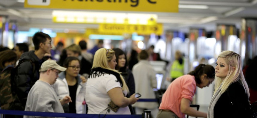 Travelers wait in lines to check in at LaGuardia Airport in New York.
