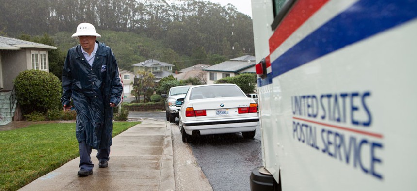 Danny Joe delivers mail as it rains in San Bruno Calif., on Thursday, Dec. 11, 2014. Joe has worked for the United States Postal Service for twenty years.