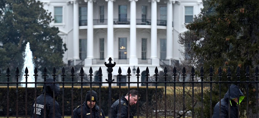 Secret Service officers search the south grounds of the White House after a drone accidentally crashed there.
