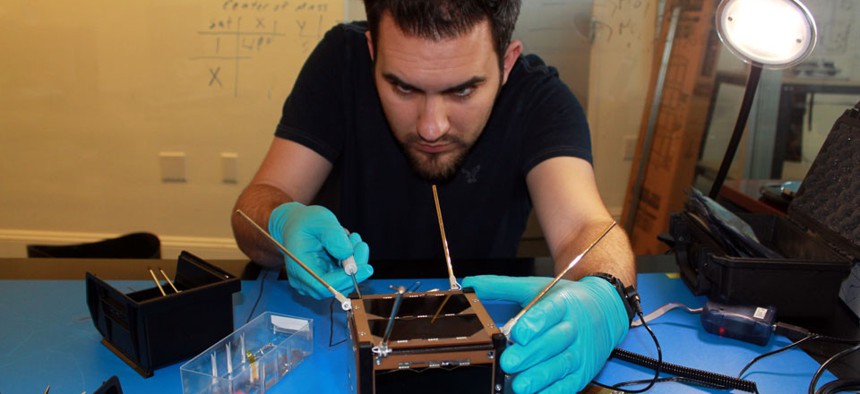 A Spire employee works on one of the company's satellites.