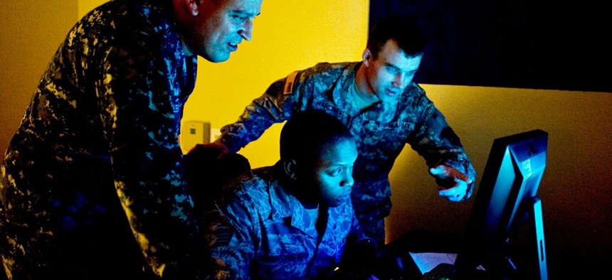 Three military cyber professionals conduct an exercise during Cyber Flag 13-1, Nov. 8, 2012, at Nellis Air Force Base, Nev. 