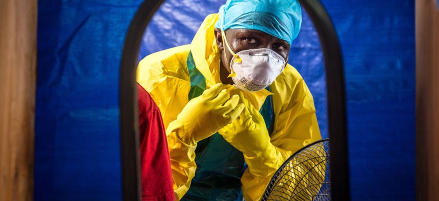 A healthcare worker dons protective gear before entering an Ebola treatment center in Freetown, Sierra Leone. 