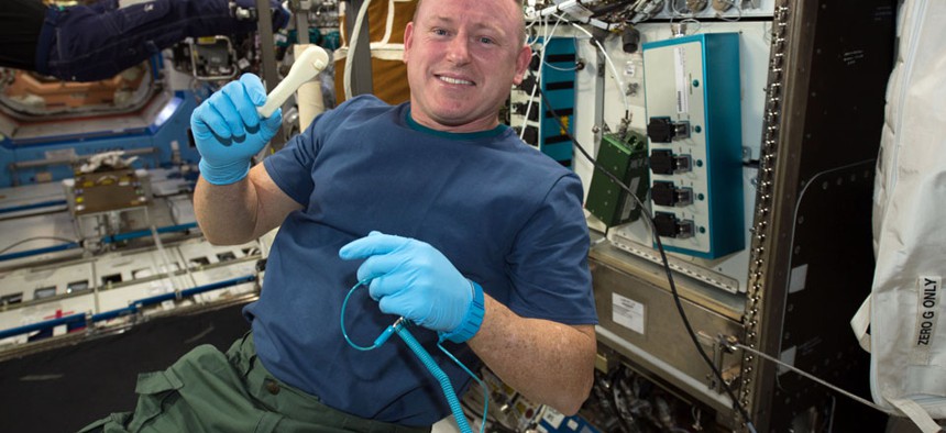International Space Station Expedition 42 Commander Barry "Butch" Wilmore shows off a ratchet wrench made with a 3-D printer on the station.