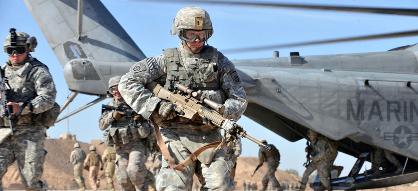 A U.S. Army soldier of the 2nd Battalion, 504th Parachute Infantry Regiment, 1st Brigade Combat Team, 82nd Airborne Division runs over to provide security after unloading from a CH-53 Sea Stallion helicopter.