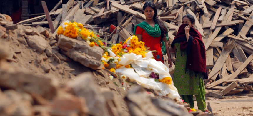 Nepalese women look at floral tributes placed in memory of victims killed in last week's earthquake, at Basantapur Durbar Square in Kathmandu, Nepal.