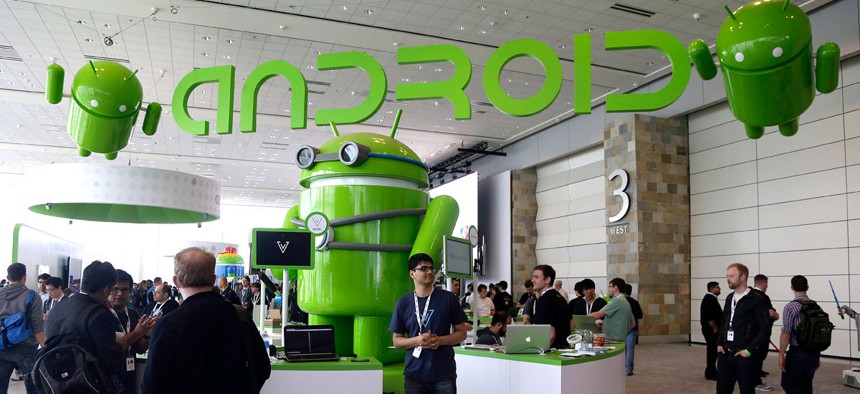 Visitors walk past the Android booth on the floor at Google I/O 2013 in San Francisco.