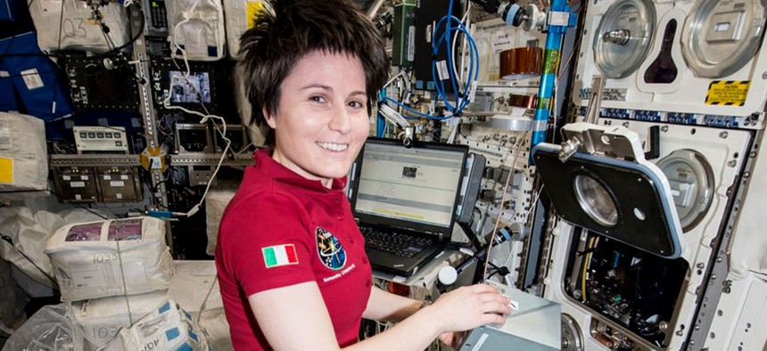 Astronaut Samantha Cristoforetti prepares an experiment on SpaceX's Dragon cargo craft.