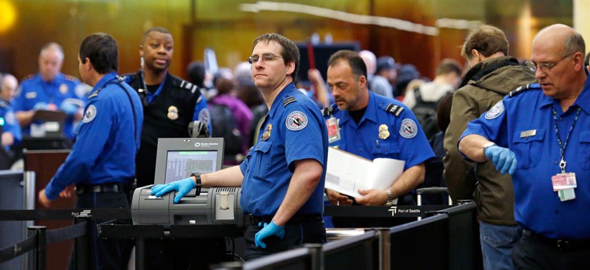 TSA agents work at a security check-point at Seattle-Tacoma International Airport