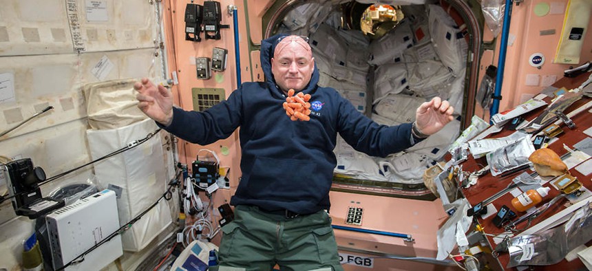 Snack time on the International Space Station as NASA astronaut Scott Kelly watches a bunch of fresh carrots float in front of him while preparing to partake of their crunchy goodness.