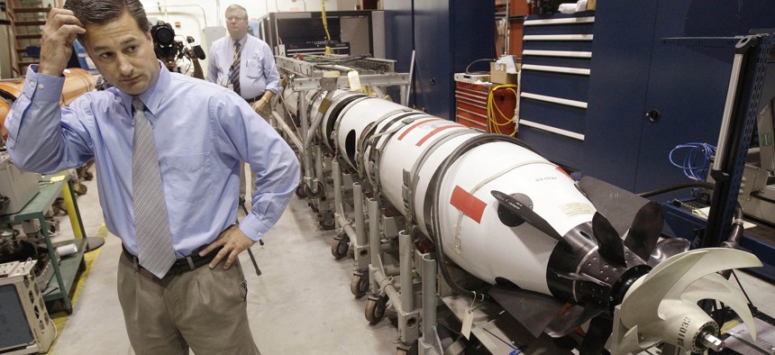 Christopher Del Mastro, head of anti submarine warfare mobil targets stands next to an unmanned underwater vehicle (UUV) in a lab at the Naval Undersea War Center in Middletown, RI.